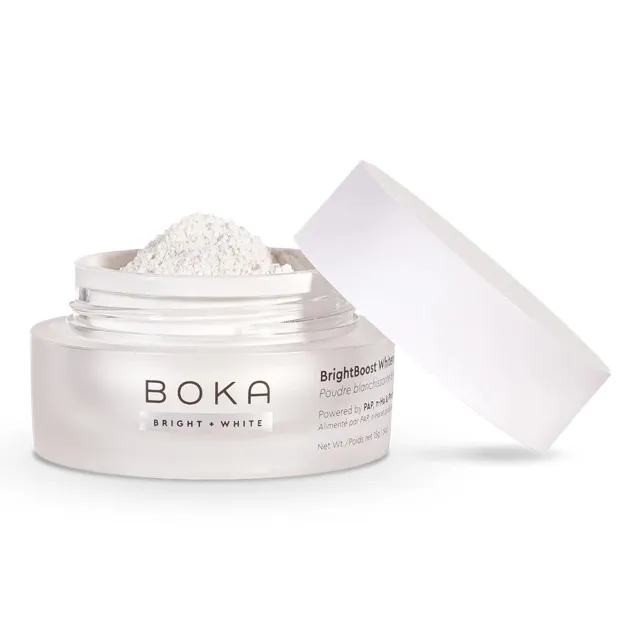 Open jar of Boka BrightBoost peroxide-free whitening powder with its lid beside it.